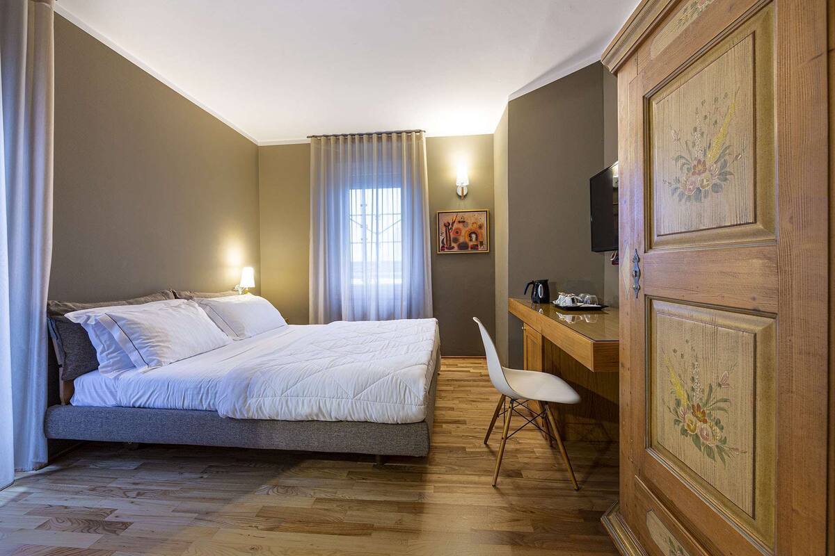 Une chambre d’hôtel comprenant un lit, un bureau, une chaise, une télévision et un placard.