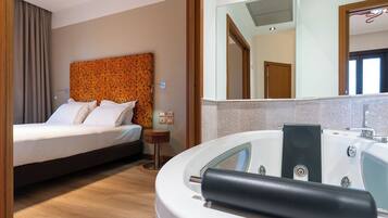 Ein Hotelzimmer mit Bett, Badezimmer mit Badewanne und Spiegel.