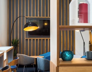 A modern interior with a wooden slat wall, a flat-screen TV, and a blue sofa. - Holiday Inn Express Strathclyde Park M74 JCT 5 by IHG (Glasgow)