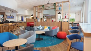 A modern cafe interior with seating arrangements, a bar area, and a large mirror. - Holiday Inn Express Strathclyde Park M74 JCT 5 by IHG (Glasgow)