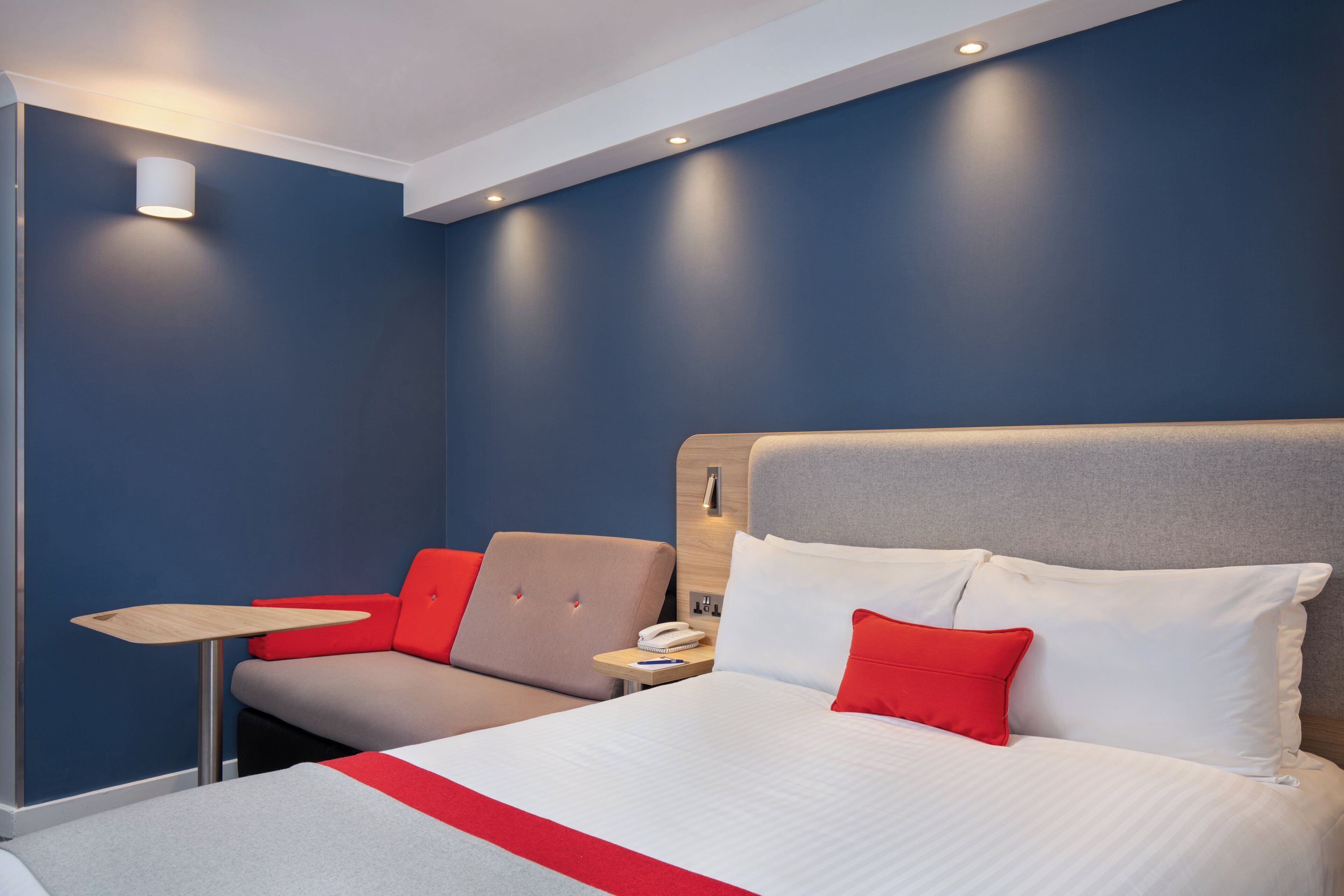 Een hotelkamer met een bed, een bureau en een stoel.