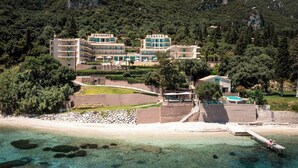 A coastal hotel with multiple buildings, a pool, and a beach area. - Canvas by Mitsis Belvedere (Corfu)