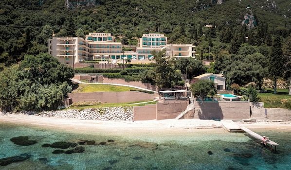 A coastal hotel with multiple buildings, a pool, and a beach area. - Canvas by Mitsis Belvedere (Corfu)