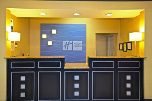 A reception area with a Holiday Inn Express sign, two reception counters, and a door leading to the lobby. - Holiday Inn Express & Suites Acworth - Kennesaw Northwest by IHG (Acworth)