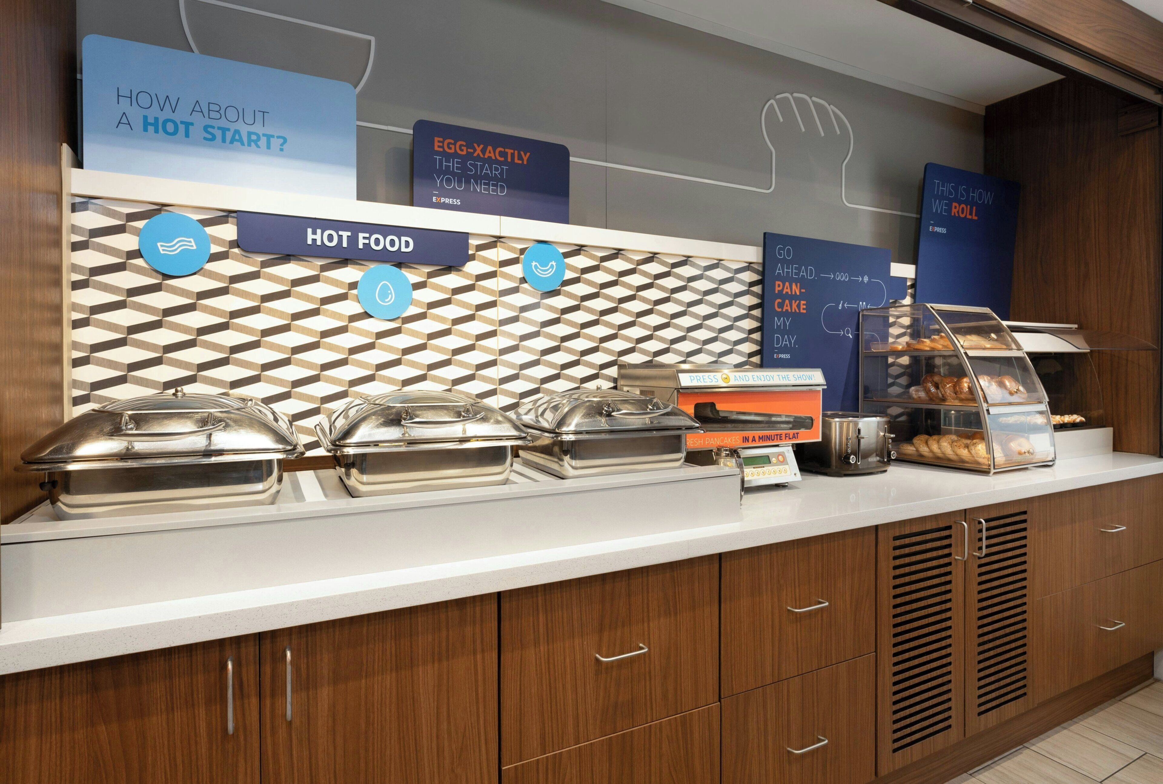 A buffet counter with various food options and signage.
