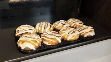 Une assiette de pâtisseries recouvertes d’un glaçage blanc, présentée sur un plateau noir.