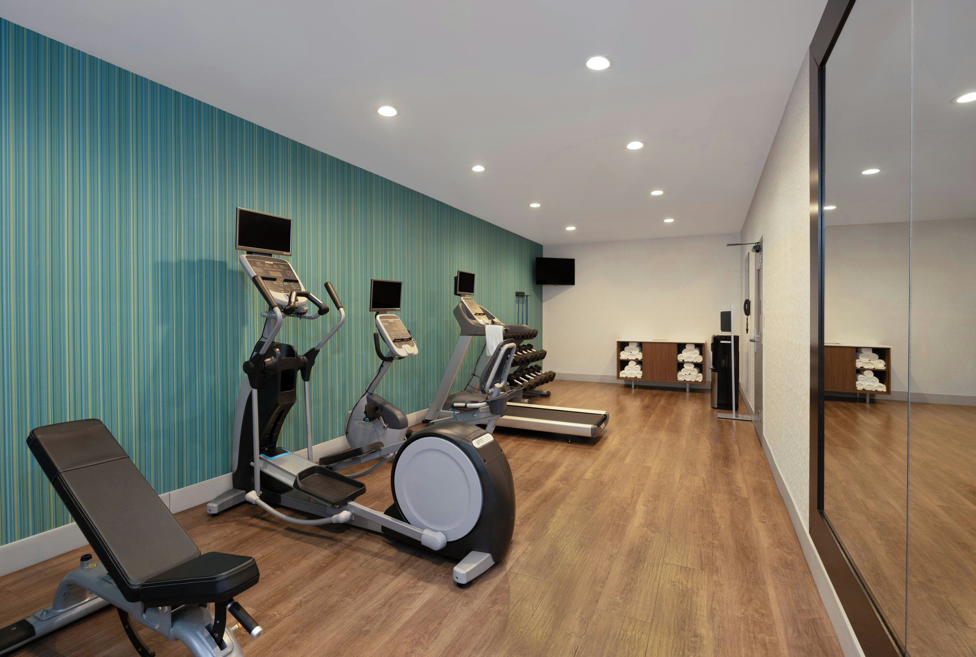 A gym with treadmills, an elliptical, and a stationary bike.