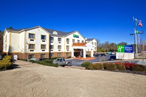 A Holiday Inn Express hotel with a prominent entrance, a parking lot, and a clear blue sky. - Holiday Inn Express & Suites Acworth - Kennesaw Northwest by IHG (Acworth)