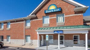 A Days Inn hotel with a brick facade, a green roof, and a registration office sign. - Days Inn by Wyndham Glen Allen/Richmond North (Glen Allen)