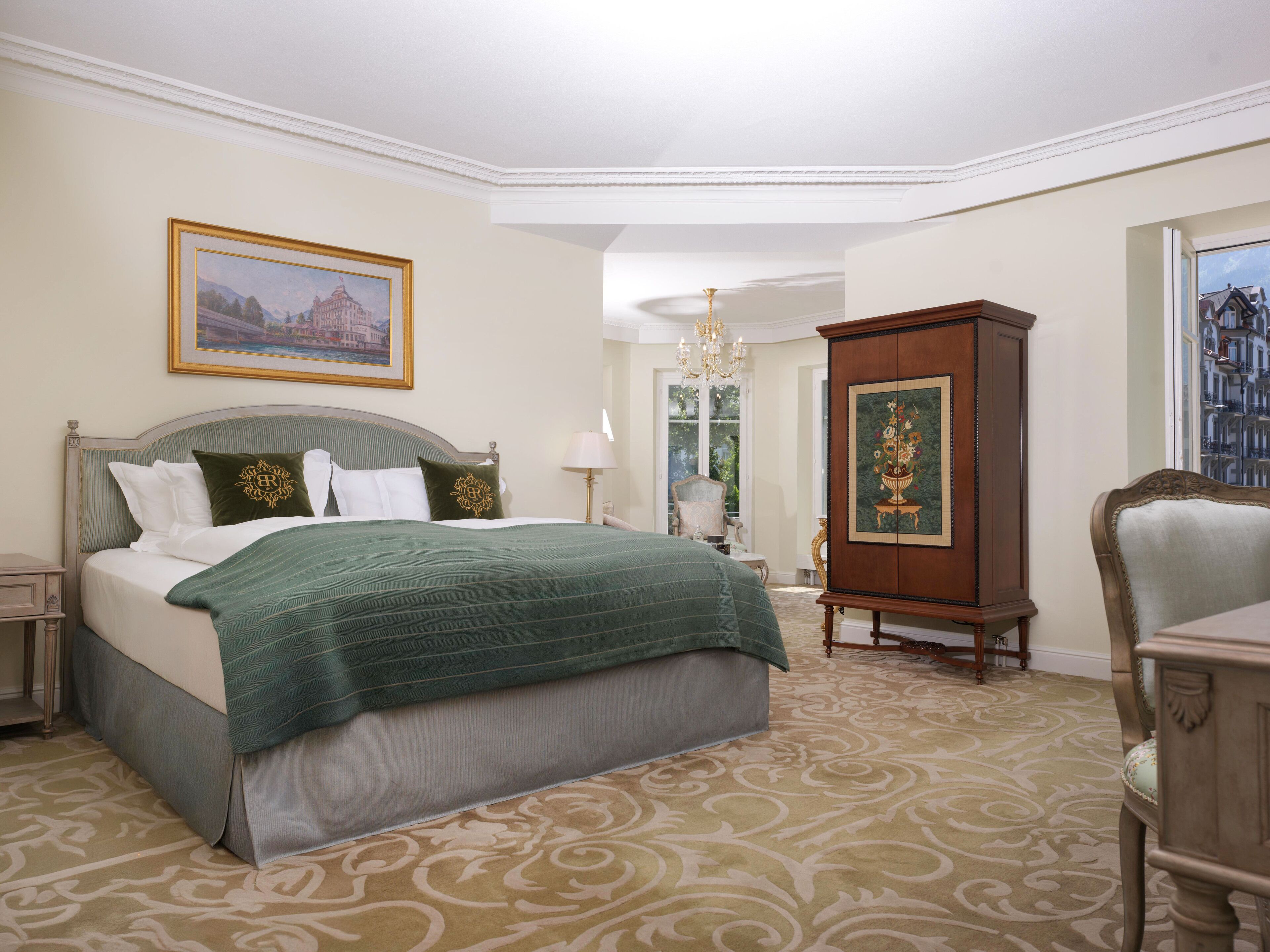 Une chambre d’hôtel avec un grand lit, une armoire en bois et une chaise.