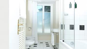 A bathroom with a black and white checkered floor, a toilet, a sink, and a shower.