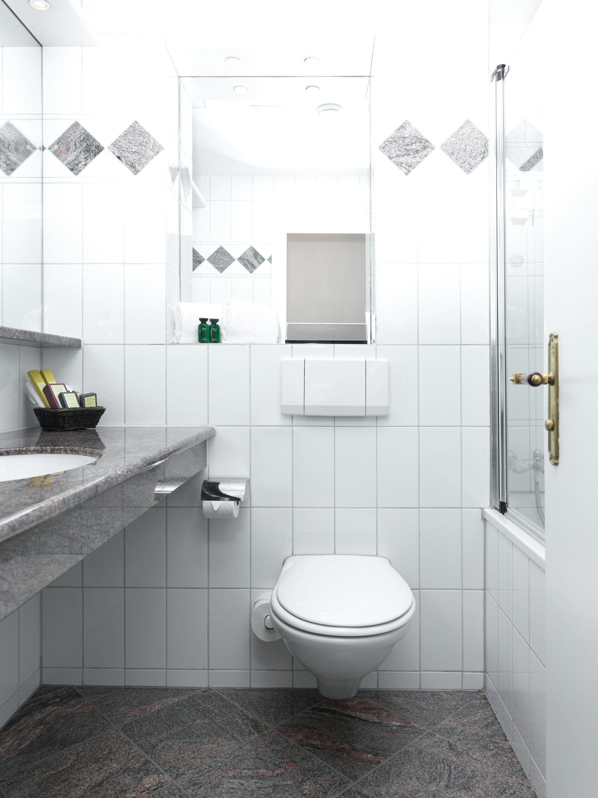 Moderni kylpyhuone, jossa on wc, pesuallas ja suihku.