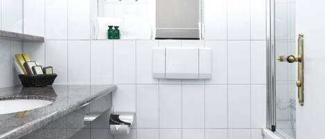 A modern bathroom with a toilet, sink, and shower.