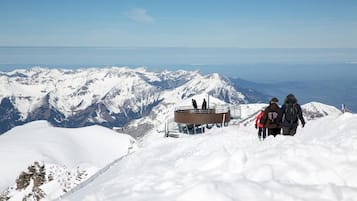 A snow-covered mountain with a viewing platform and a clear sky.