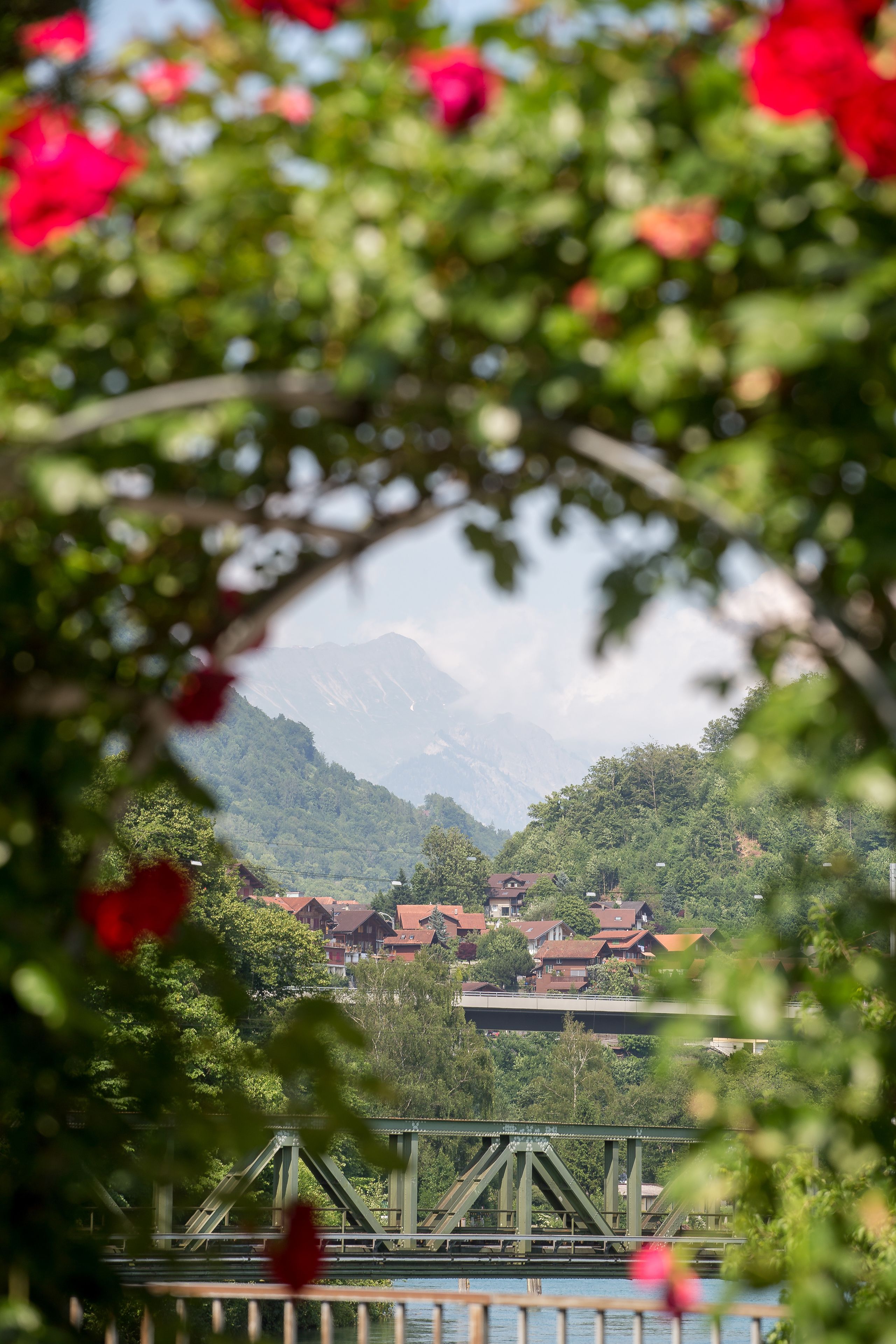 Un puente con vista a un pueblo y montañas al fondo.
