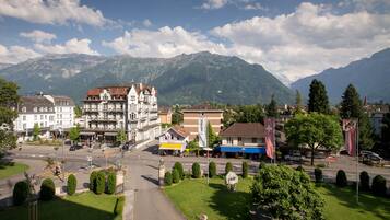 A town square with buildings, a flag, and mountains in the background.