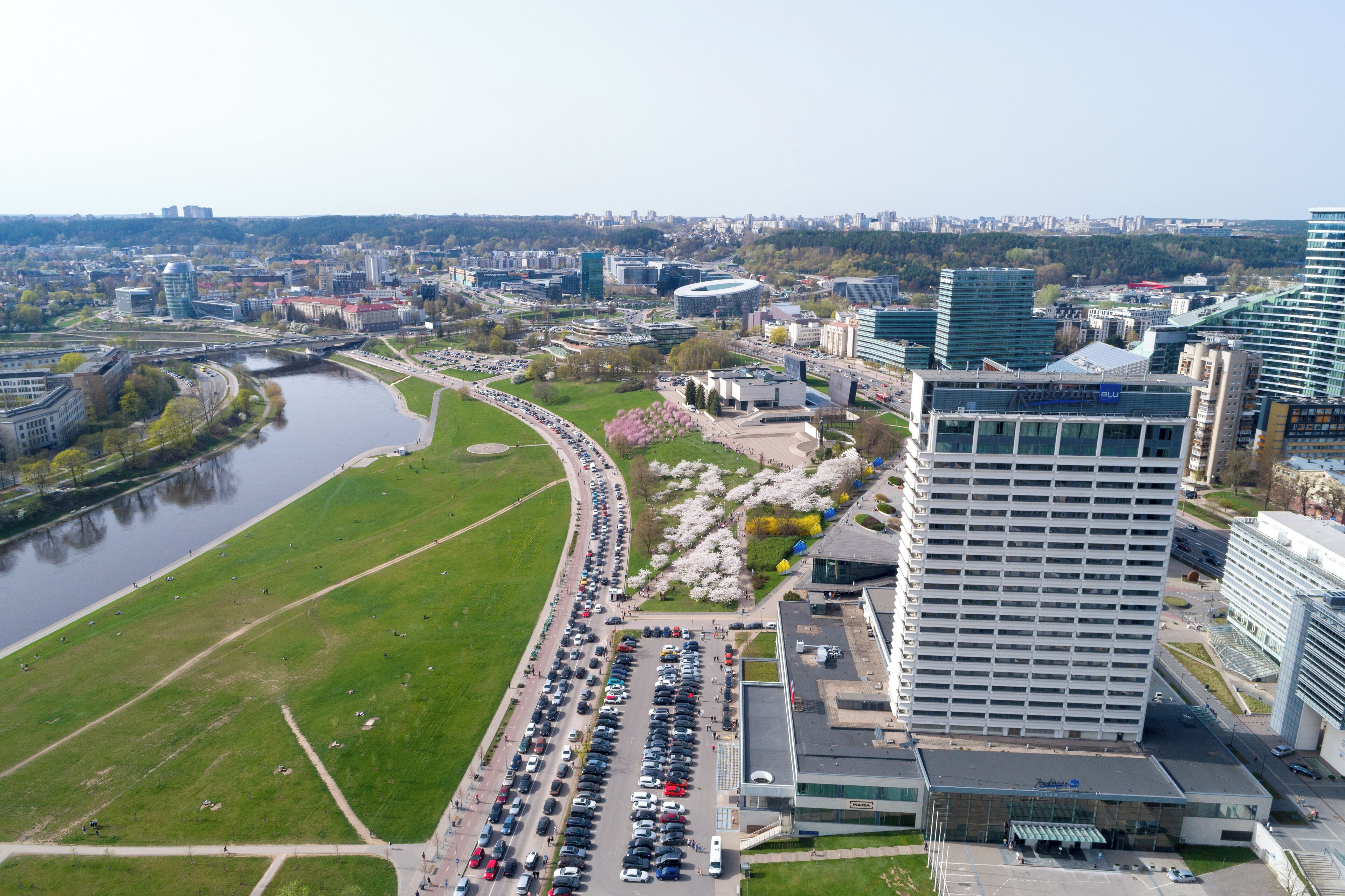 An urban landscape with a river, green spaces, and modern buildings.