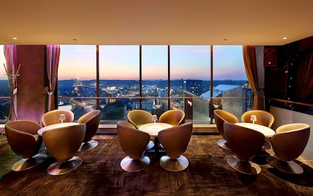 A modern room with a large window, a round table, and six chairs.