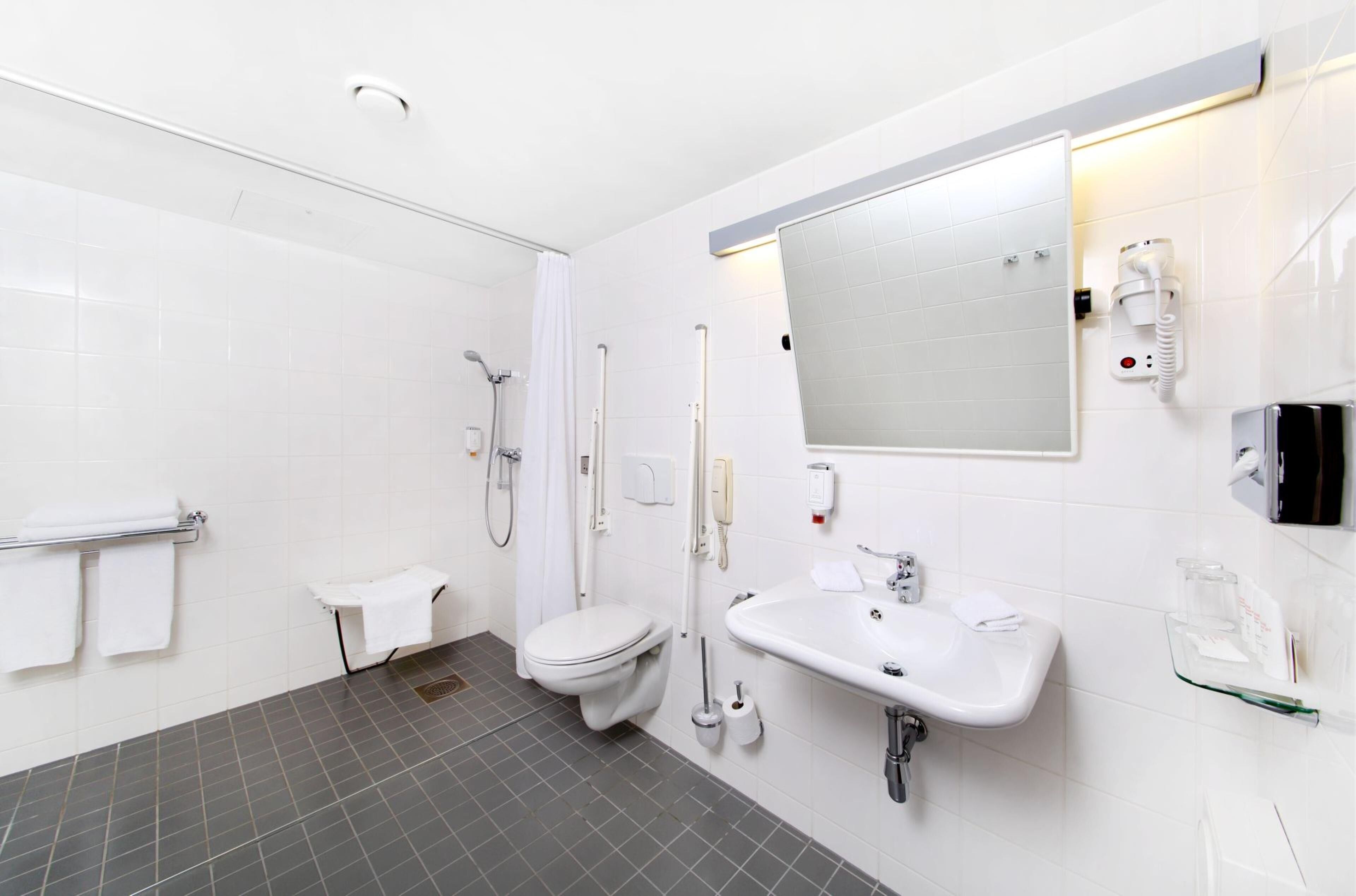 Un baño moderno con inodoro, lavamanos y ducha.