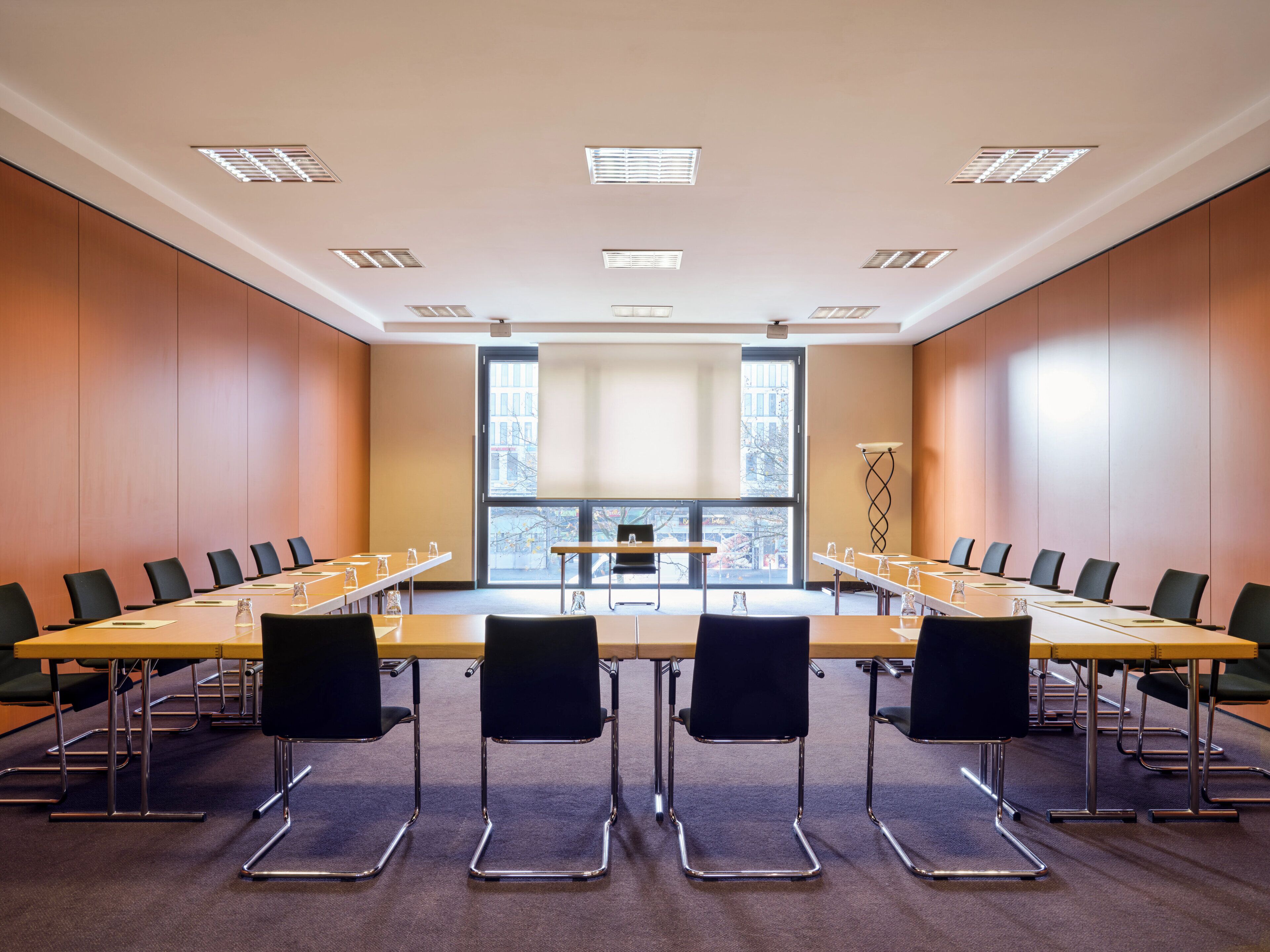 A conference room with a long table, chairs, and a large window.