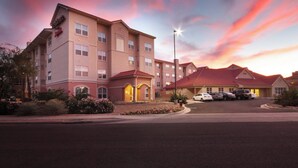 A hotel with a red roof, multiple floors, and a parking lot with several cars. - Residence Inn by Marriott Tucson Williams Centre (Tucson)