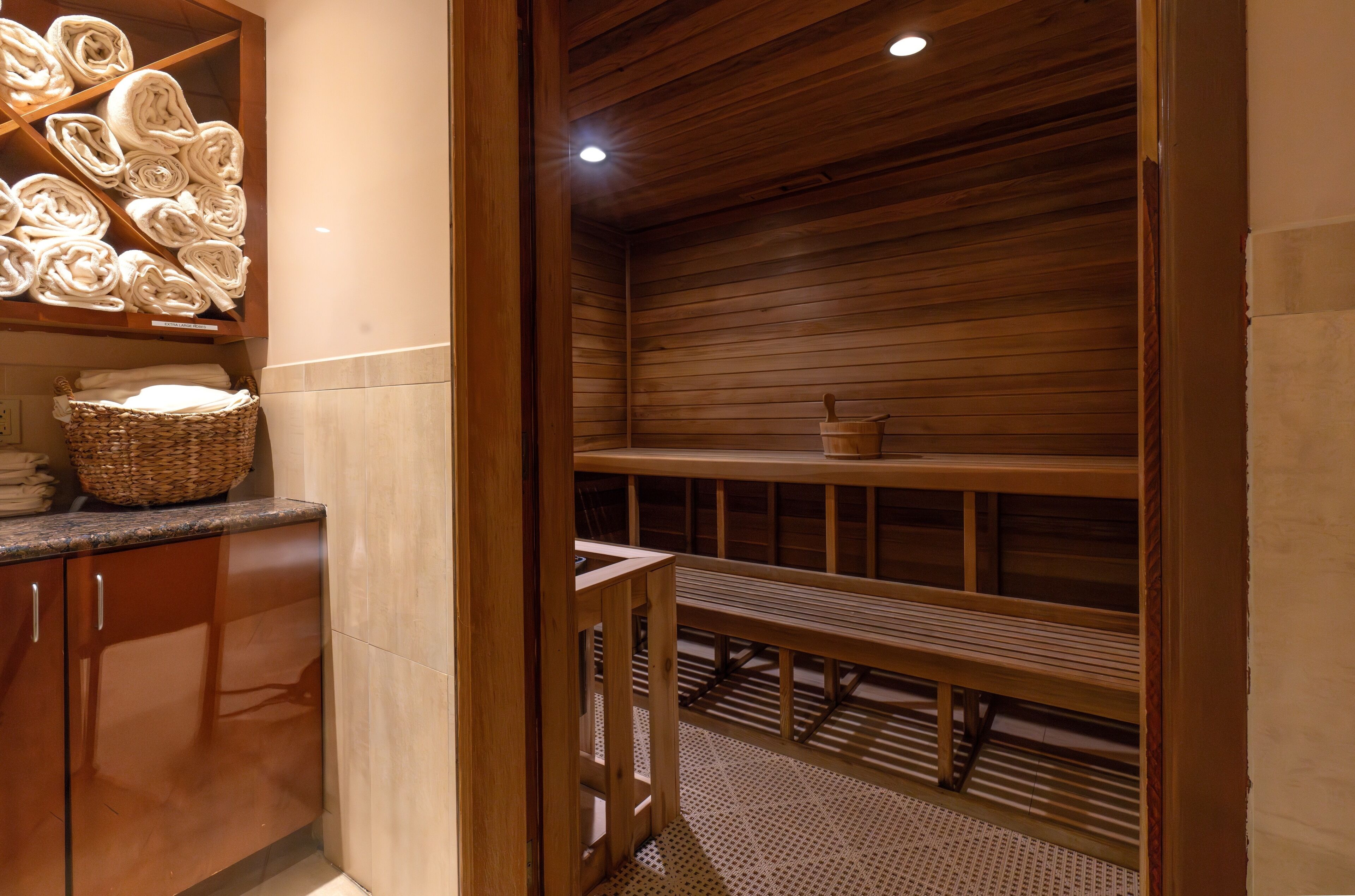 A sauna room with wooden benches and a wooden ceiling.