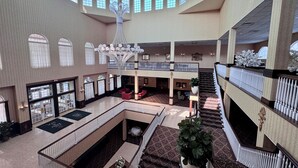 Un rebedor d'hotel espaiós amb diversos nivells, un penjador central i una escala que mena al pis superior.