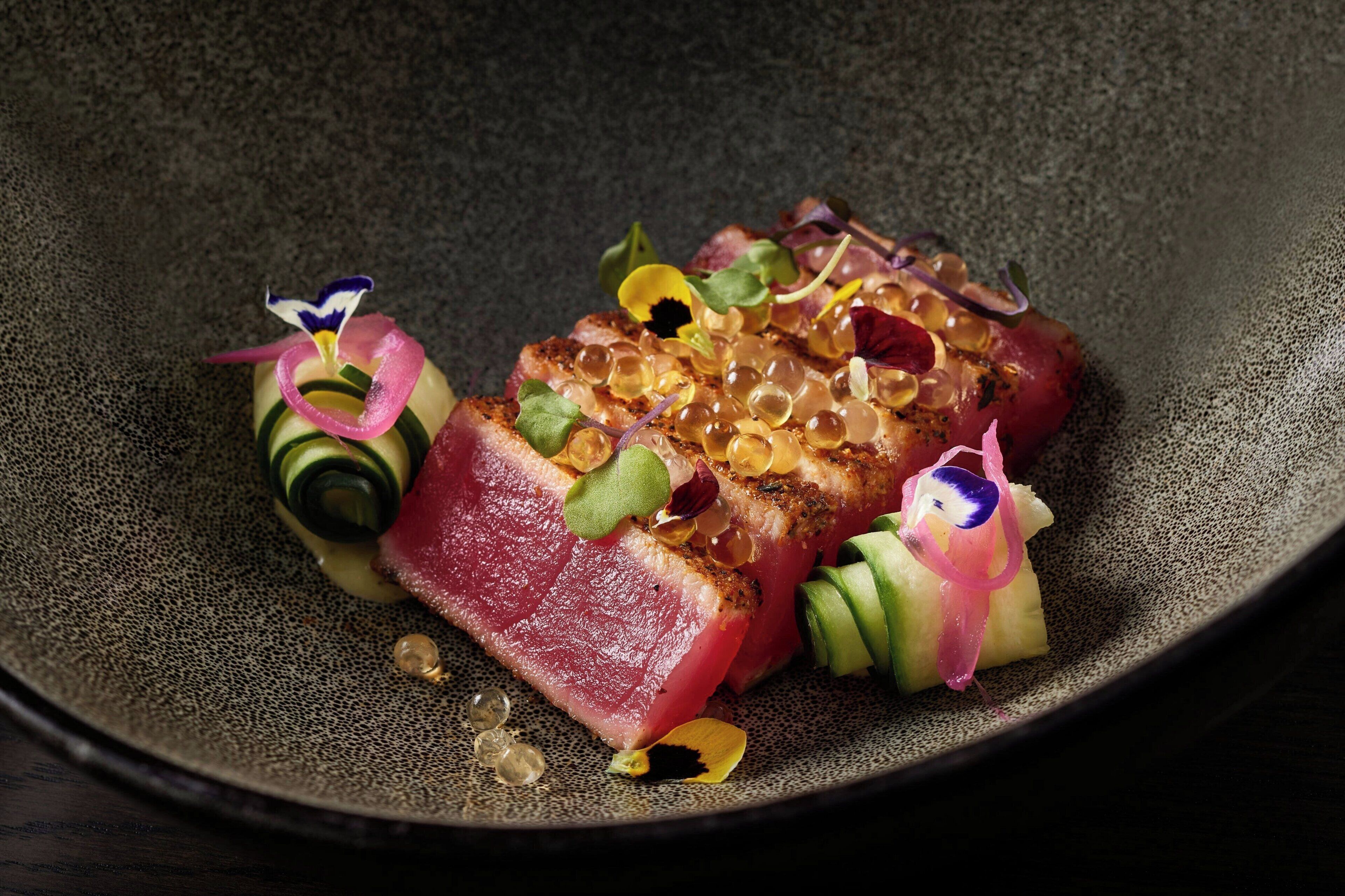 A dish with various garnishes and a textured plate.