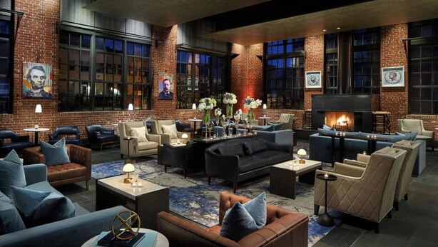 A spacious lounge area with leather sofas, armchairs, and a fireplace. - The Ritz-Carlton Georgetown, Washington, D.C. (Washington)