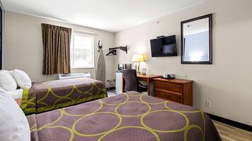 A hotel room with two beds, a desk, a chair, a TV, and a window with curtains.