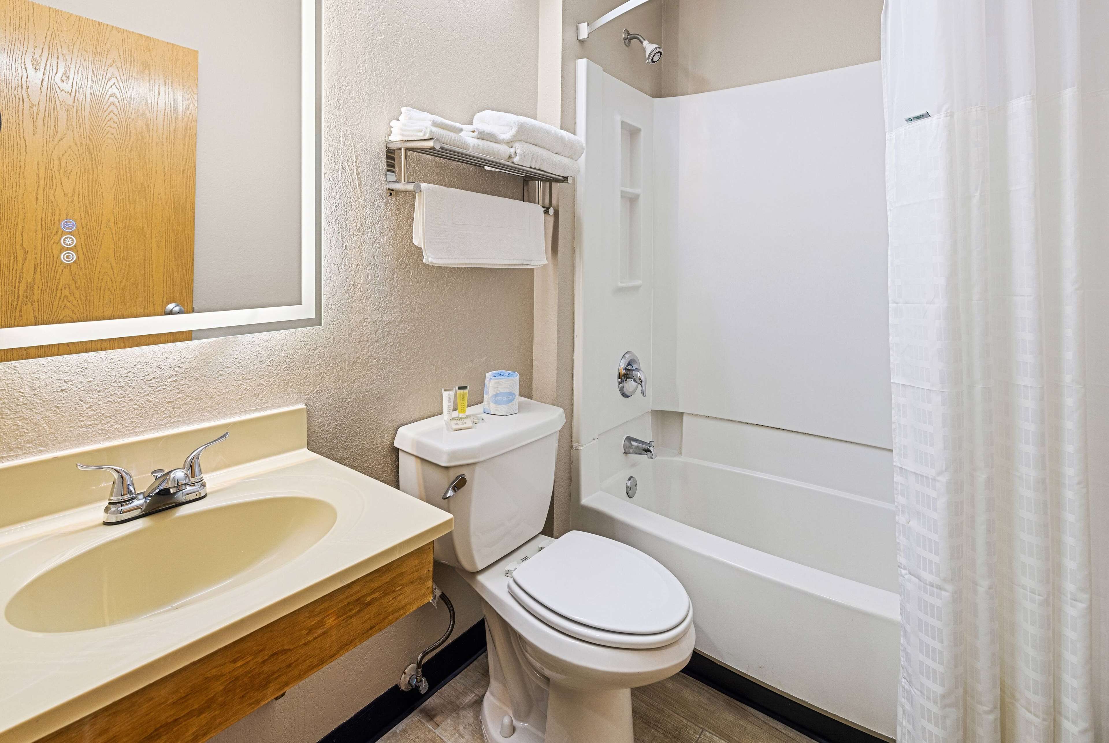 Un baño con lavamanos, inodoro y bañera.