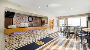 A reception area with a wooden counter, a clock, and a patterned wall. - Super 8 by Wyndham Pittsburgh/Monroeville (Pittsburgh)