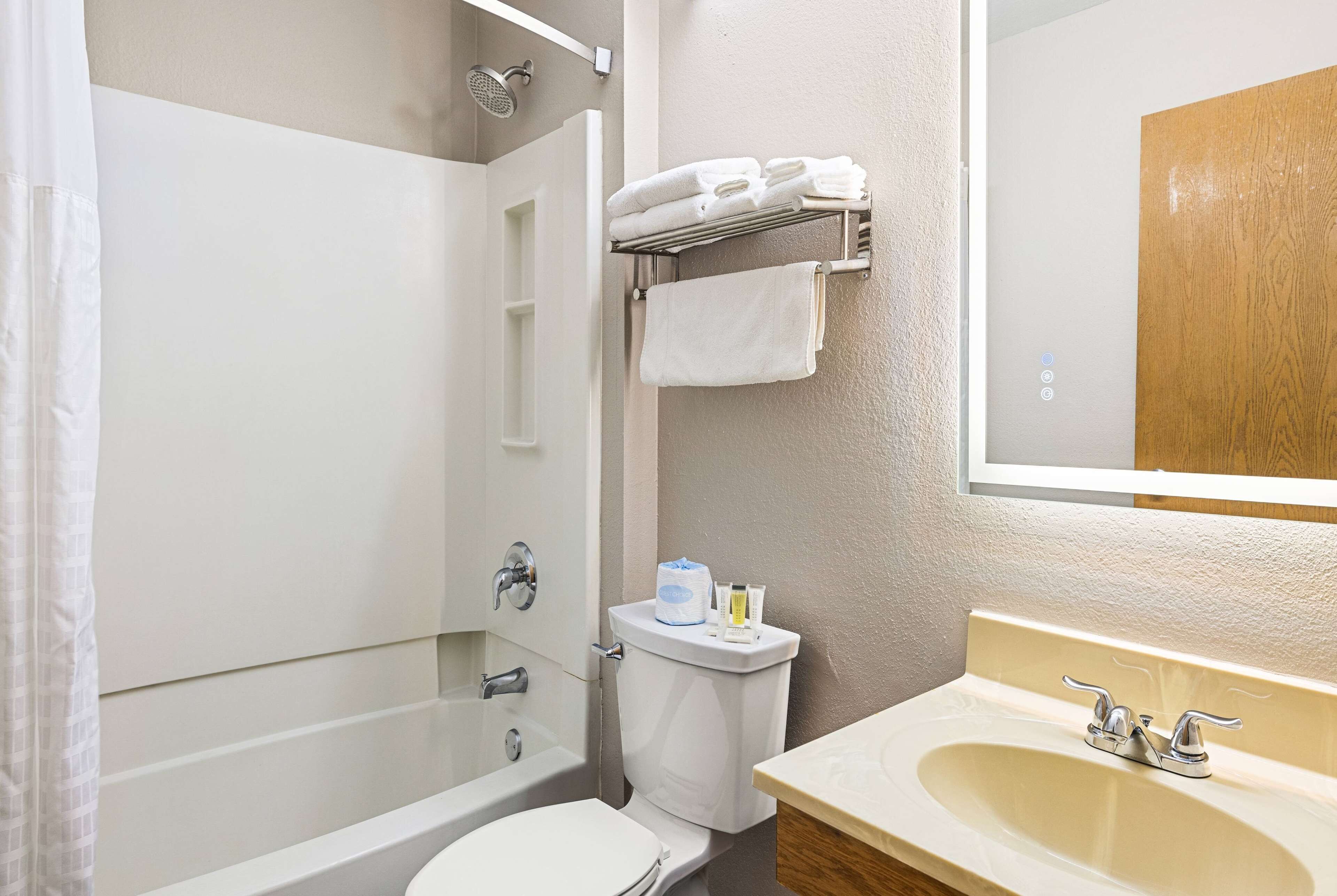 A bathroom with a bathtub, toilet, sink, and towel rack.