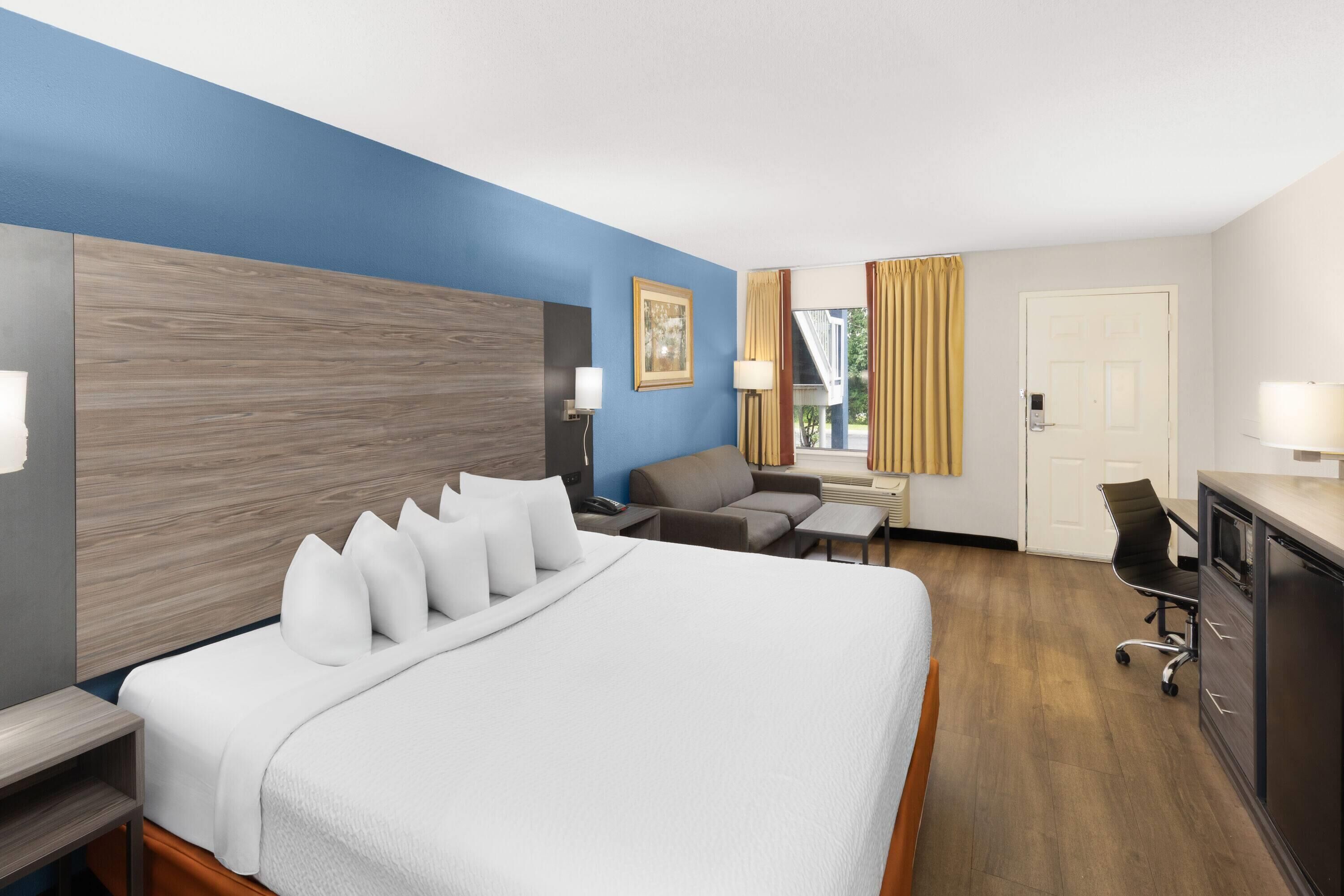 Een hotelkamer met een groot bed, een bureau, een stoel en een bank.
