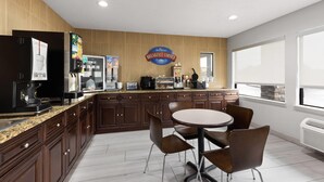 Una cocina moderna con barra de desayuno, máquinas de café y un letrero que dice 'Breakfast Corner'.