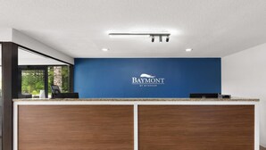 Un mostrador de recepción con una pared azul y un logotipo que dice 'Baymont by Wyndham'.