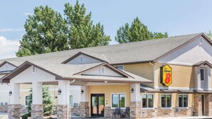 Un hôtel doté d’une entrée couverte, de piliers en pierre et d’une enseigne « Super 8 ».