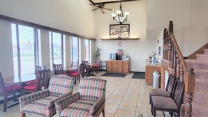 A spacious living room with a dining area, a kitchen, and a staircase leading to an upper floor.