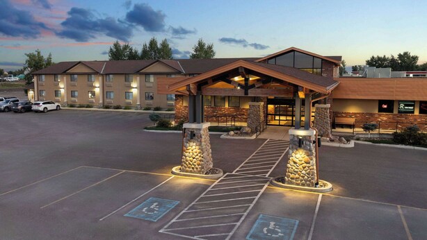 A hotel with a covered entrance, handicap parking, and a parking lot. - Super 8 by Wyndham Conrad (Conrad)