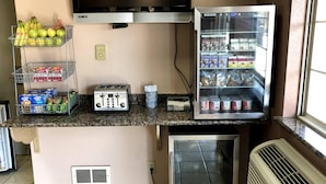 A kitchenette with a toaster, a mini-fridge, a mini-refrigerator, and a TV mounted above the counter. - Anthony Inn (Anthony)