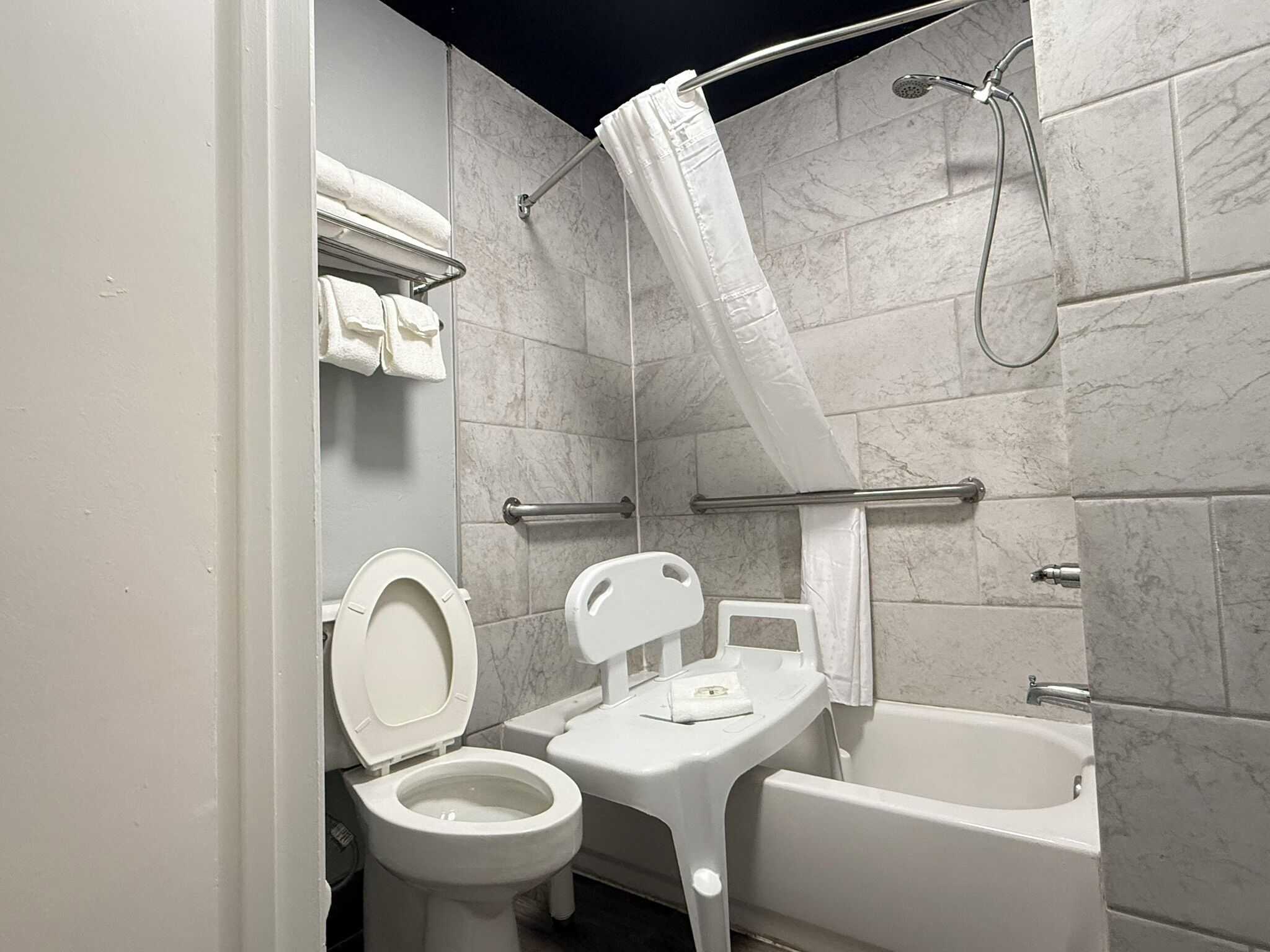 A bathroom with a toilet, a small sink, and a bathtub.