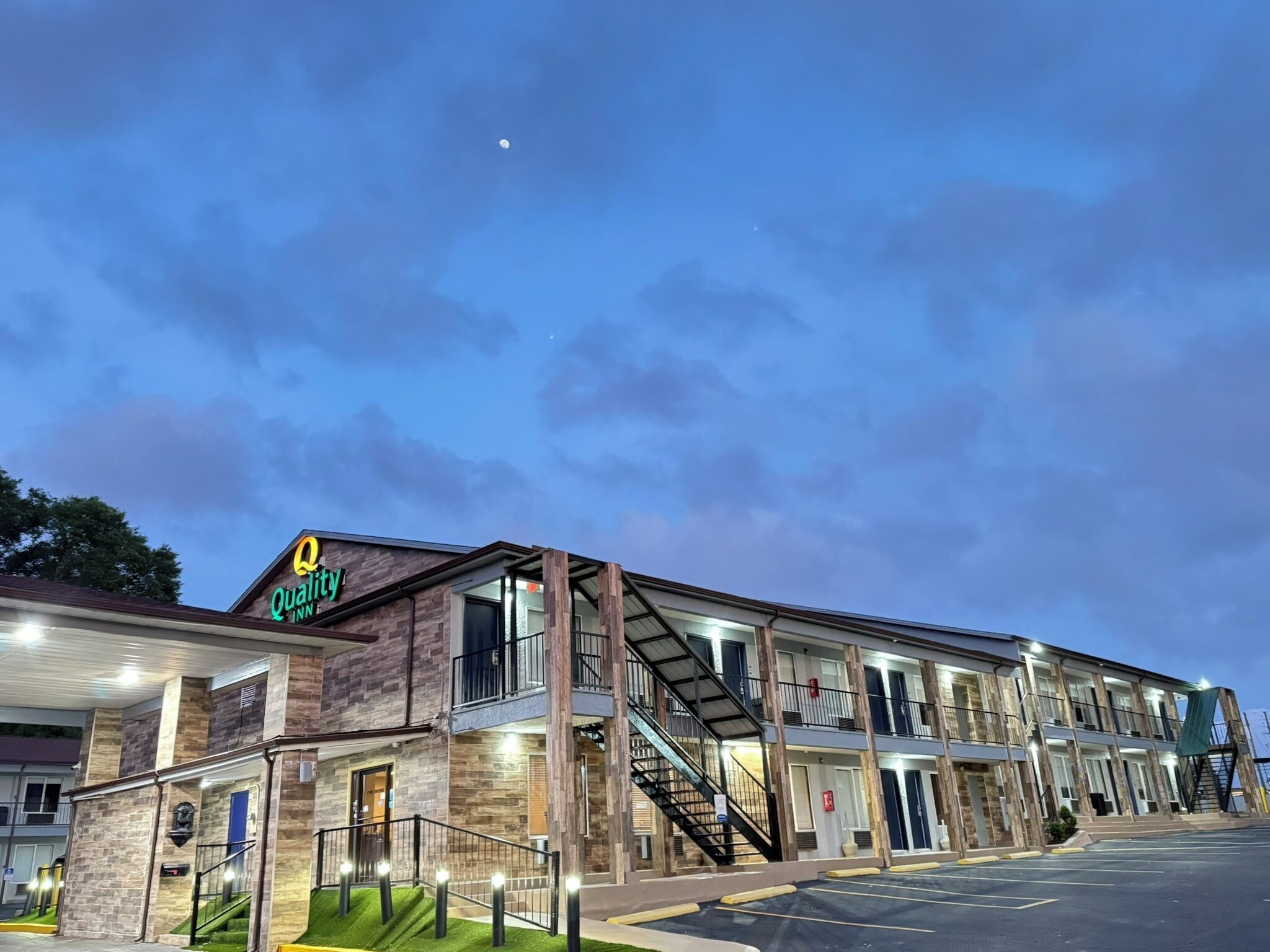 A hotel with a modern design, featuring a prominent sign for 'Quality Inn'.