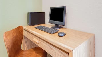 Un escritorio de madera con un equipo informático que incluye un monitor, teclado y ratón.