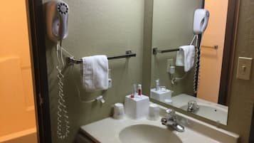 A bathroom with a sink, mirror, towel rack, and hair dryer.