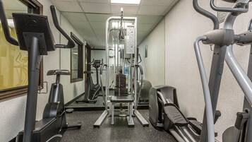 A gym with various exercise equipment including treadmills, an elliptical, and a weight machine.