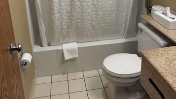 A bathroom with a white shower curtain, a toilet, and a sink with a towel rack.