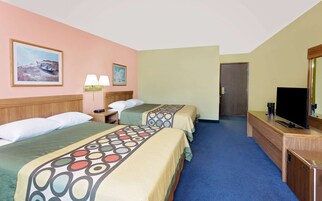 Habitación de hotel con dos camas, televisión, escritorio y un cuadro en la pared.