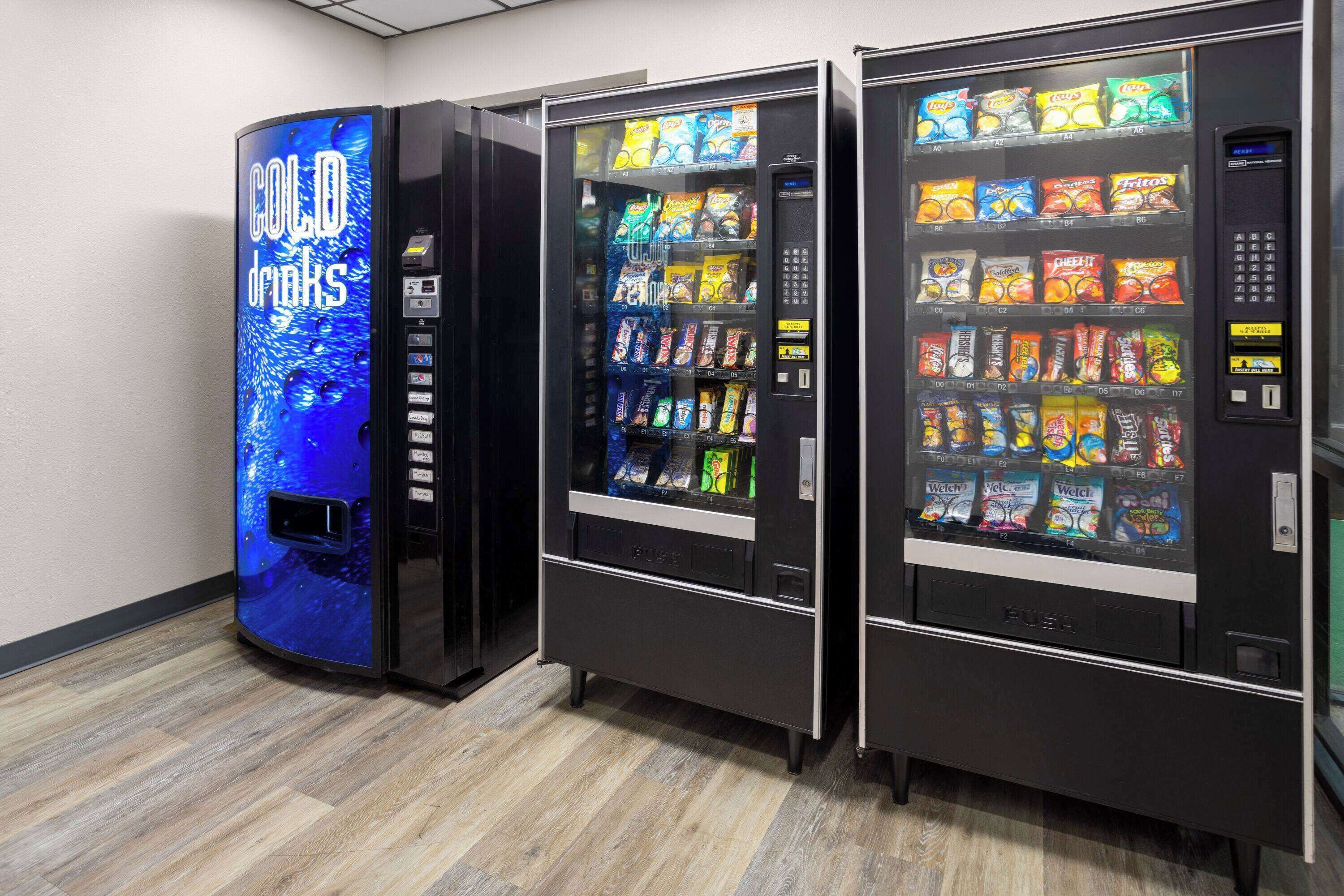 Three vending machines with a variety of snacks and drinks.