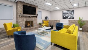 Un área de estar moderna con chimenea, asientos cómodos y un televisor de pantalla plana.