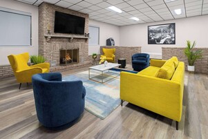 Uma área de estar moderna com lareira, assentos confortáveis e uma TV de tela plana.